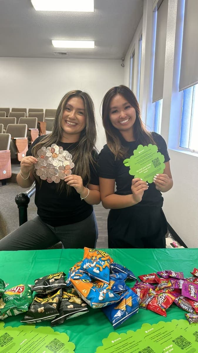 Two students running a branded sampling table